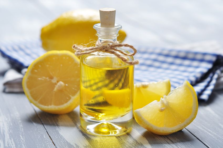 21356191 - lemon oil in a glass bottle with fresh lemon on wooden background